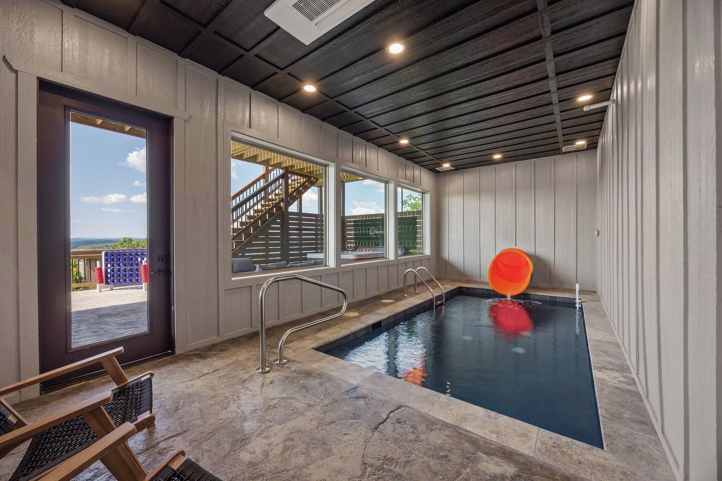 A swimming pool with a view of a staircase leading outside.
