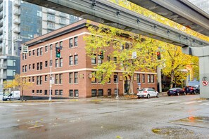 A multi-story brick building with a 'ONE WAY' sign, a 'FIFTH AVENUE COURT' sign, and a 'RIGHT LANE' sign indicating a bus lane. - Belltown Couples Retreat with Easy Access to Lumen Field (Seattle)