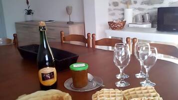 Une table à manger avec une bouteille, un bocal et des assiettes remplies de nourriture.