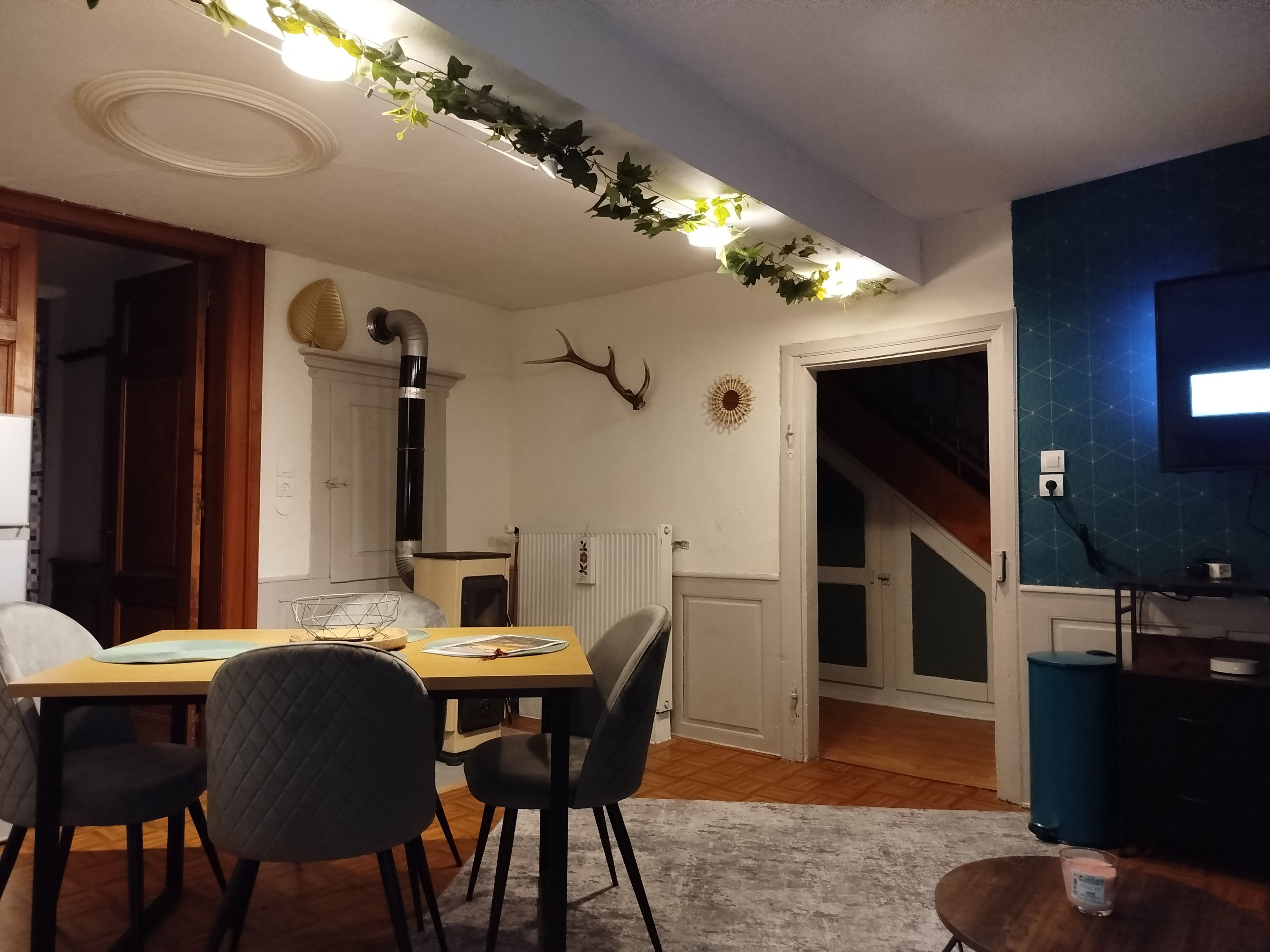 Un coin repas avec une table, des chaises et un radiateur.