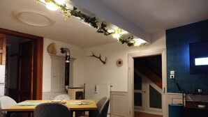 A dining area with a table, chairs, and a radiator. - The Great Cozy Safari (Petersbach)