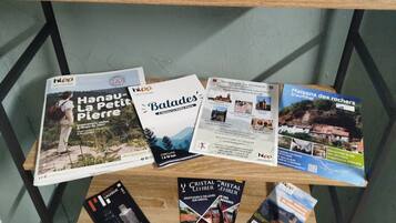 Une étagère en bois où sont posées des brochures et des guides de voyage.
