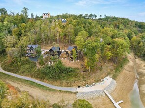A residential area with multiple houses, a dirt road, and a body of water. - VIEWS-Luxe-Beach Access-Pets-Games-Hot Tub (Sevierville)