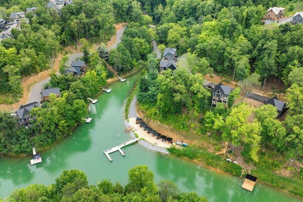 A river with boats, surrounded by houses and dense greenery. - Private Dock-Lakefront-Views-Pets-Beach Access (Sevierville)