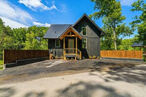 A two-story wooden cabin with a porch, surrounded by a wooden fence and trees. - Lakefront-Private Dock-Pets-VIEWS-Beach Access (Sevierville)