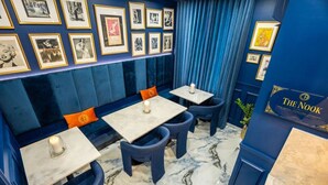 A room with a blue wall, framed pictures, a sign reading 'The Nook,' and a marble floor. - Casa Azul - Your Own Private Boutique Hotel for 12 - Breakfast Included (San Juan)
