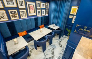 A room with a blue wall, framed pictures, a sign reading 'The Nook,' and a marble floor. - Casa Azul - Your Own Private Boutique Hotel for 12 - Breakfast Included (San Juan)