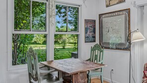 A room with a large window, a table, two chairs, and a lamp. - Woodstock Vermont Escape with Space to Slow Down (Woodstock)