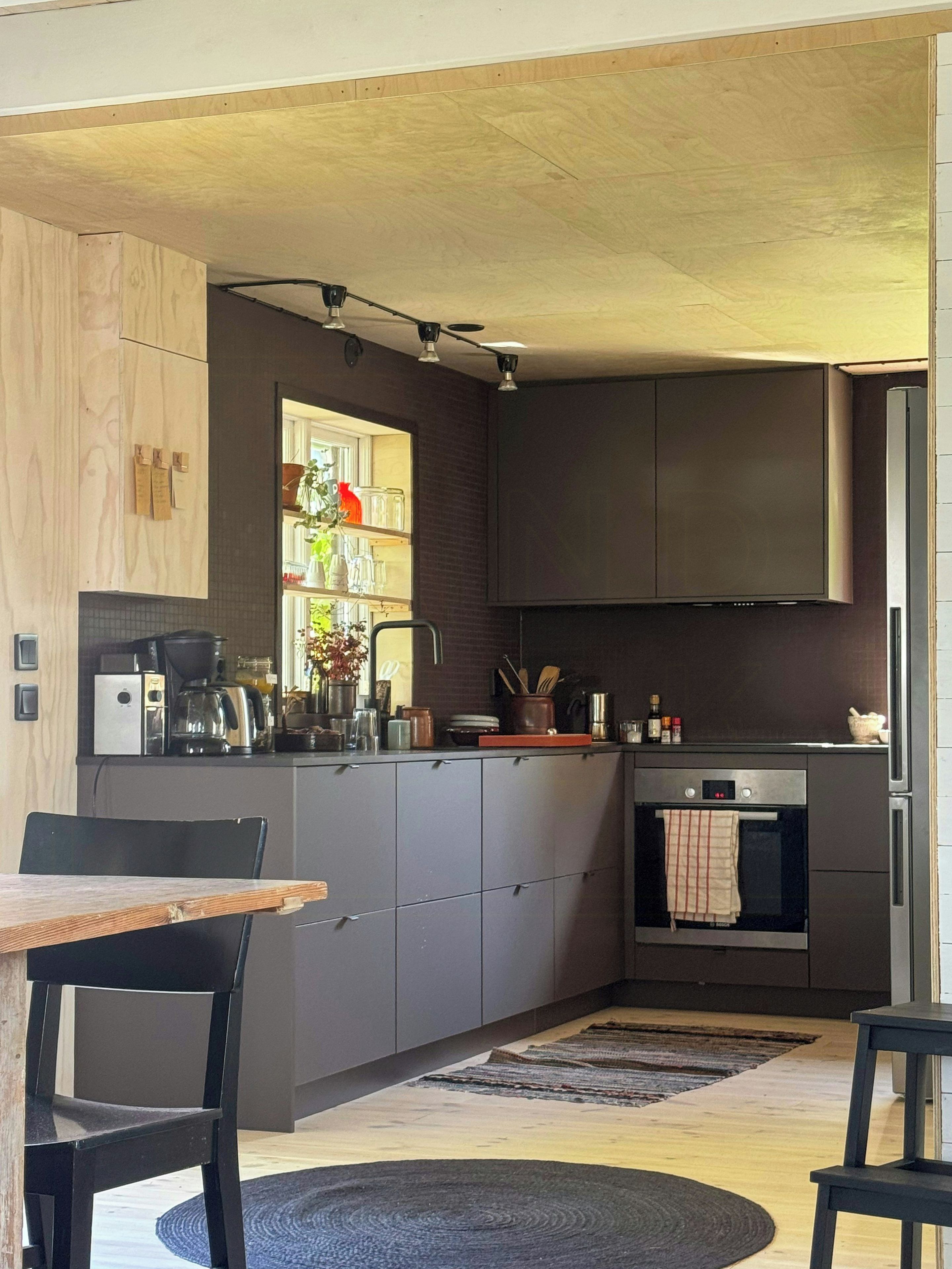 Une cuisine moderne dotée d’un îlot central, d’appareils électroménagers intégrés et d’un coin repas avec une table et des chaises.