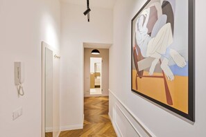 Ein Flur mit Telefon, einem gerahmten Kunstwerk und einer Tür zum Badezimmer.