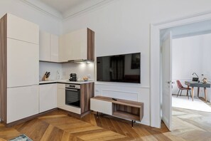 Eine moderne Küche mit weißen Schränken, einem eingebauten Backofen und einer Holzarbeitsplatte.
