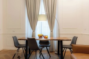 Ein Essbereich mit Tisch, Stühlen, einer Lampe und einer Obstschale.