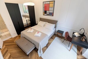 Ein Hotelzimmer mit Bett, Schreibtisch, Stuhl und einem kleinen Tisch.