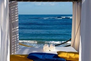 A bed with a view of the ocean, a rope, and two pillows. - 2BR VIP Residence Suites, All-Inclusive, Gold band, Puerto Plata, DR (Puerto Plata)