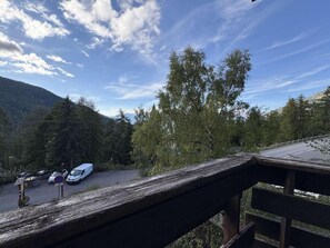 A parking area with vehicles, a wooden fence, and a mountainous backdrop. - 40m from ski slopes, 2nd floor, view valley, balcony, 18m², Les Orres (Les Orres)