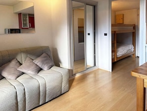 A room with a sofa, a bunk bed, and a wooden table. - 40m from ski slopes, 2nd floor, view valley, balcony, 18m², Les Orres (Les Orres)