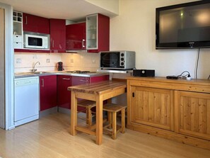 A compact kitchen with a microwave, toaster, and a flat-screen TV mounted on the wall. - 40m from ski slopes, 2nd floor, view valley, balcony, 18m², Les Orres (Les Orres)