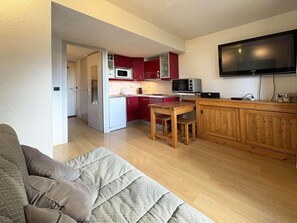 A compact living space with a kitchenette, a dining area, and a TV mounted on the wall. - 40m from ski slopes, 2nd floor, view valley, balcony, 18m², Les Orres (Les Orres)