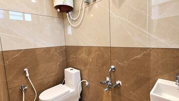 Une salle de bain moderne équipée de toilettes, d’une douche et d’un lavabo.