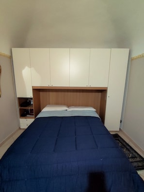 A bedroom with a bed, a wardrobe, and a nightstand. - Accommodation located in an 18th-century building, cozy, family-friendly, (Alessandria)