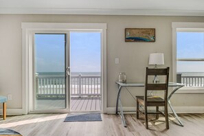 Ein Zimmer mit Blick auf das Meer, ein Tisch mit einer Lampe und ein Stuhl.