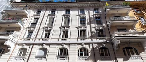 A multi-story building with classical architecture, featuring ornate balconies and large windows.