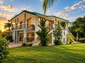 A two-story house with a balcony, surrounded by lush greenery. - Casa Carmín-3BR & Pet Friendly- San Sebastian (San Sebastián)