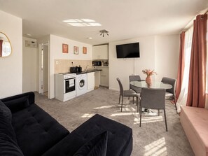 A compact living space with a kitchenette, a dining area, and a seating area. - Stylish Fitzrovia 1BR Near Oxford Street (Greater London)