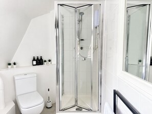 A modern bathroom with a glass-enclosed shower, white fixtures, and a toilet. - Spacious Fitzrovia Studio Near Oxford Street (Greater London)
