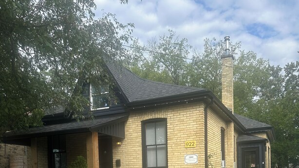 A single-story brick building with a chimney, a front door, and a small porch. - 1880 Yellow-Brick Cottage Executive Retreat (London)