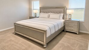 Ein Schlafzimmer mit einem Bett, zwei Nachttischen und einem Beistelltisch.