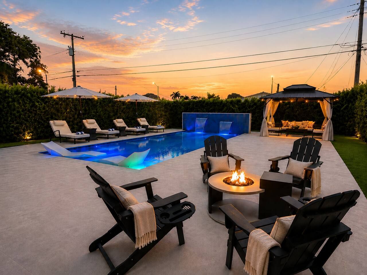 A poolside area with lounge chairs, a fire pit, and a covered seating area.