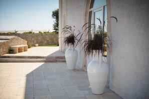 A pathway leading to a building with large white vases on the ground. - Dimora Bellarosa - A Timeless Masseria with Infinity Pool (Puglia)