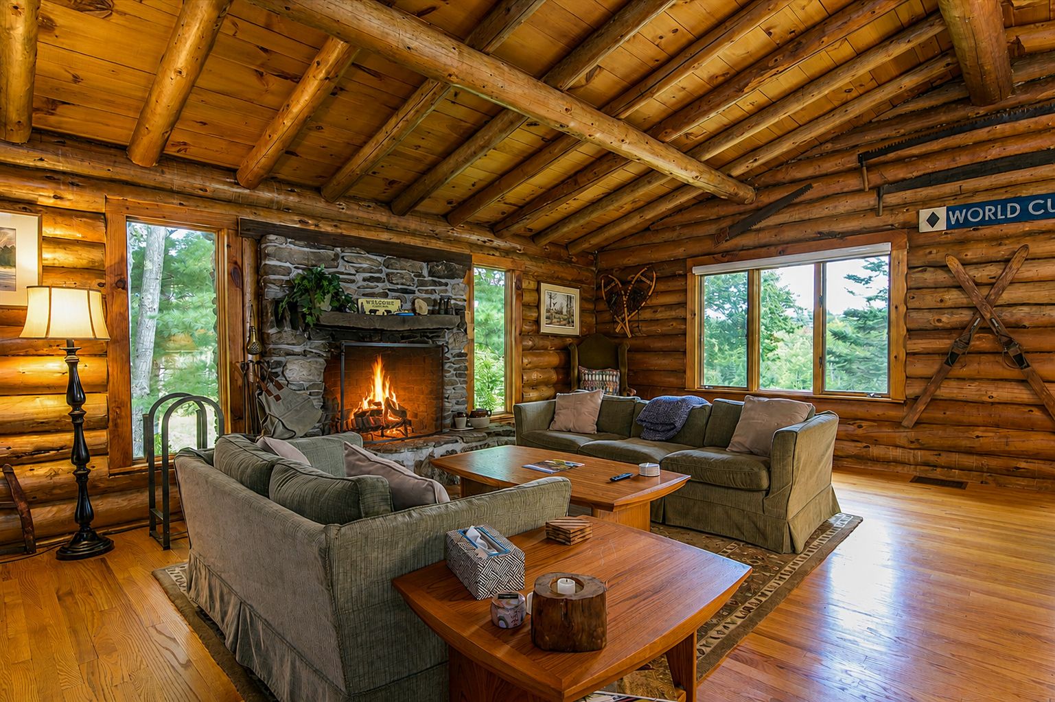 A log cabin interior with a stone fireplace, wooden furniture, and a 'WORLD CUP' sign.