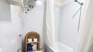 Et lille, moderne badeværelse med toilet, bruser og badekar.