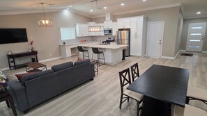 A modern kitchen with white cabinets, a central island, and stainless steel appliances.