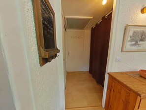 A narrow hallway with a wooden cabinet and a framed picture on the wall. - Ground floor, terrace, parking, tv, ski locker, 37m², Le Grand Bornand (Le Grand-Bornand)