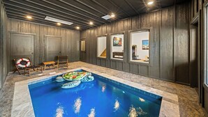 Una piscina con bordo in legno, una panchina e un galleggiante.