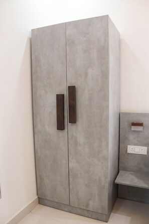 A grey wardrobe with two doors and a wooden handle. - OnlyStay Business Suites Hitech city (Hyderabad)