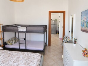 Ein Stockbett mit unterem Bett, ein Nachttisch mit Spiegel und eine Kommode mit Dekoration.