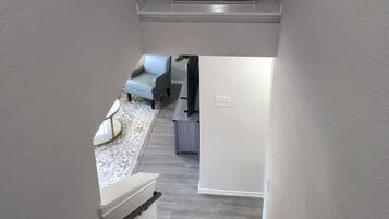 A staircase leading to a living area with a framed map on the wall.