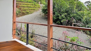 Zona d'estar a l'aire lliure coberta amb vista a un jardí ben mantingut i un camí.