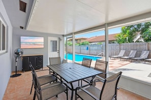 A covered patio with a pool, outdoor furniture, and a dining area. - Boynton Beach Escape | Private Pool + 3BR (Boynton Beach)