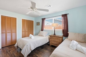 A room with two beds, a ceiling fan, a window with curtains, and a wooden wardrobe. - Boynton Beach Escape | Private Pool + 3BR (Boynton Beach)
