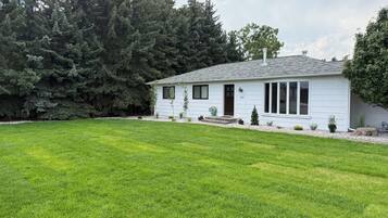A single-story house with a well-maintained lawn and a small garden area.