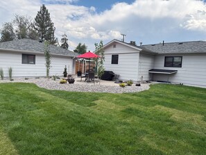 A residential property with a patio area, a barbecue grill, and a covered seating area.