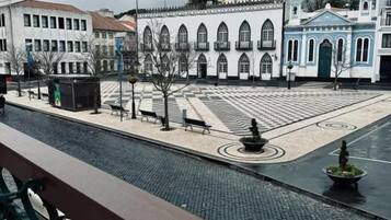 Un patio con una fuente, bancos y suelo de baldosas.