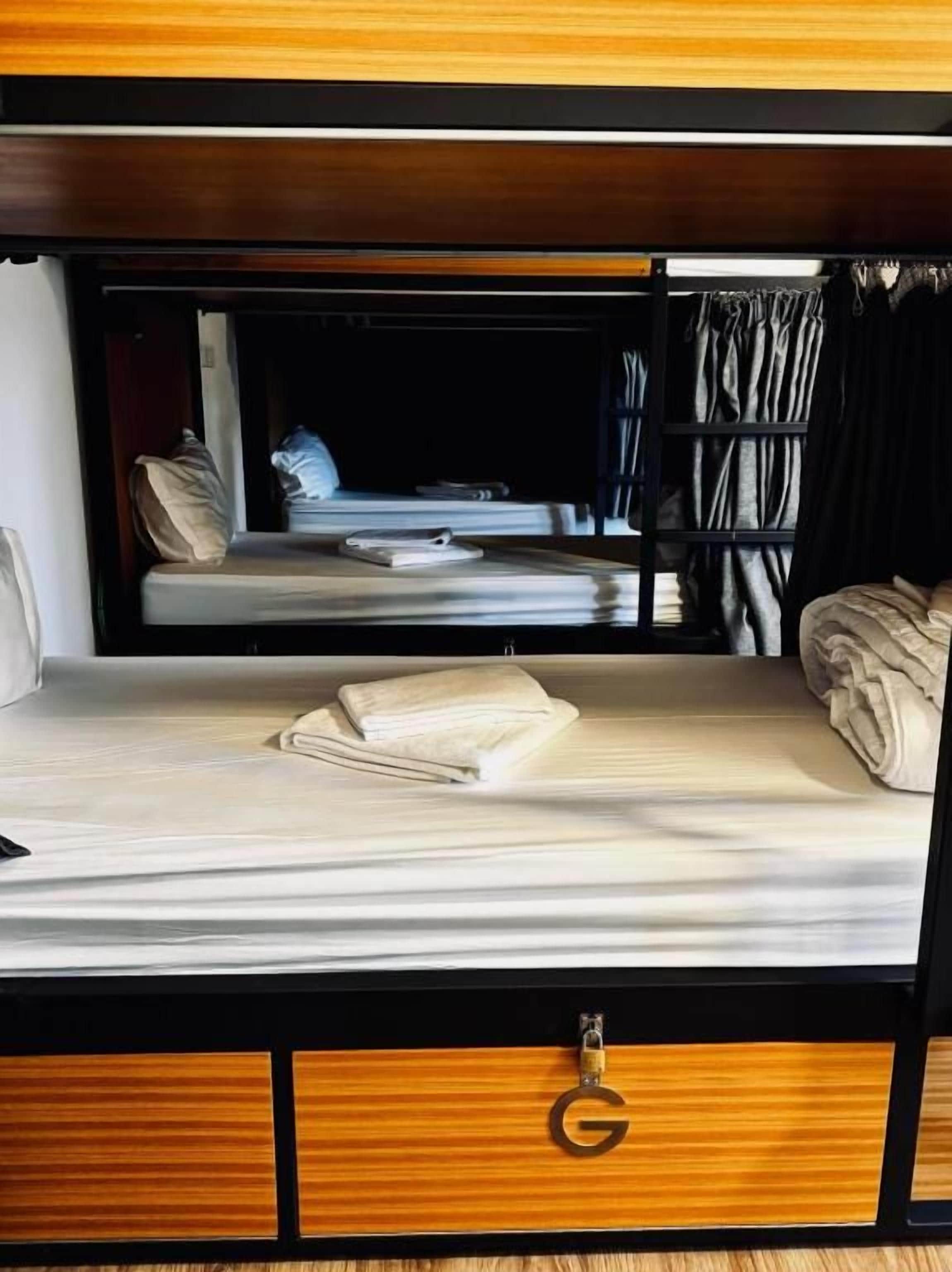 A bunk bed with a wooden headboard and a small drawer with a lock.