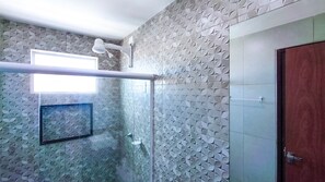 A bathroom with patterned walls, a shower area, and a door. - Prive Paraiso Praia dos Carneiros (Tamandaré)
