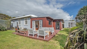 Una casa móvil de dos pisos con un patio, mobiliario exterior y una parrilla.